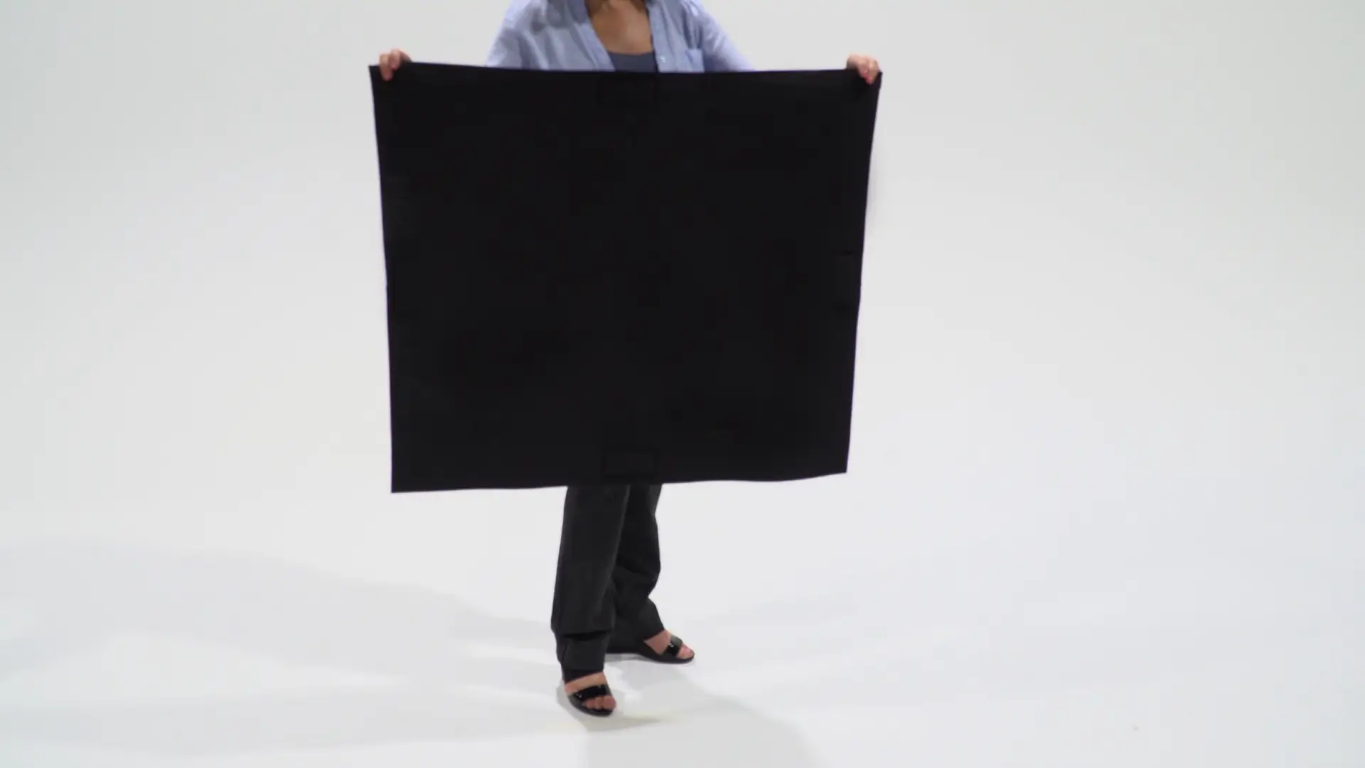 A person holding up a large black board.